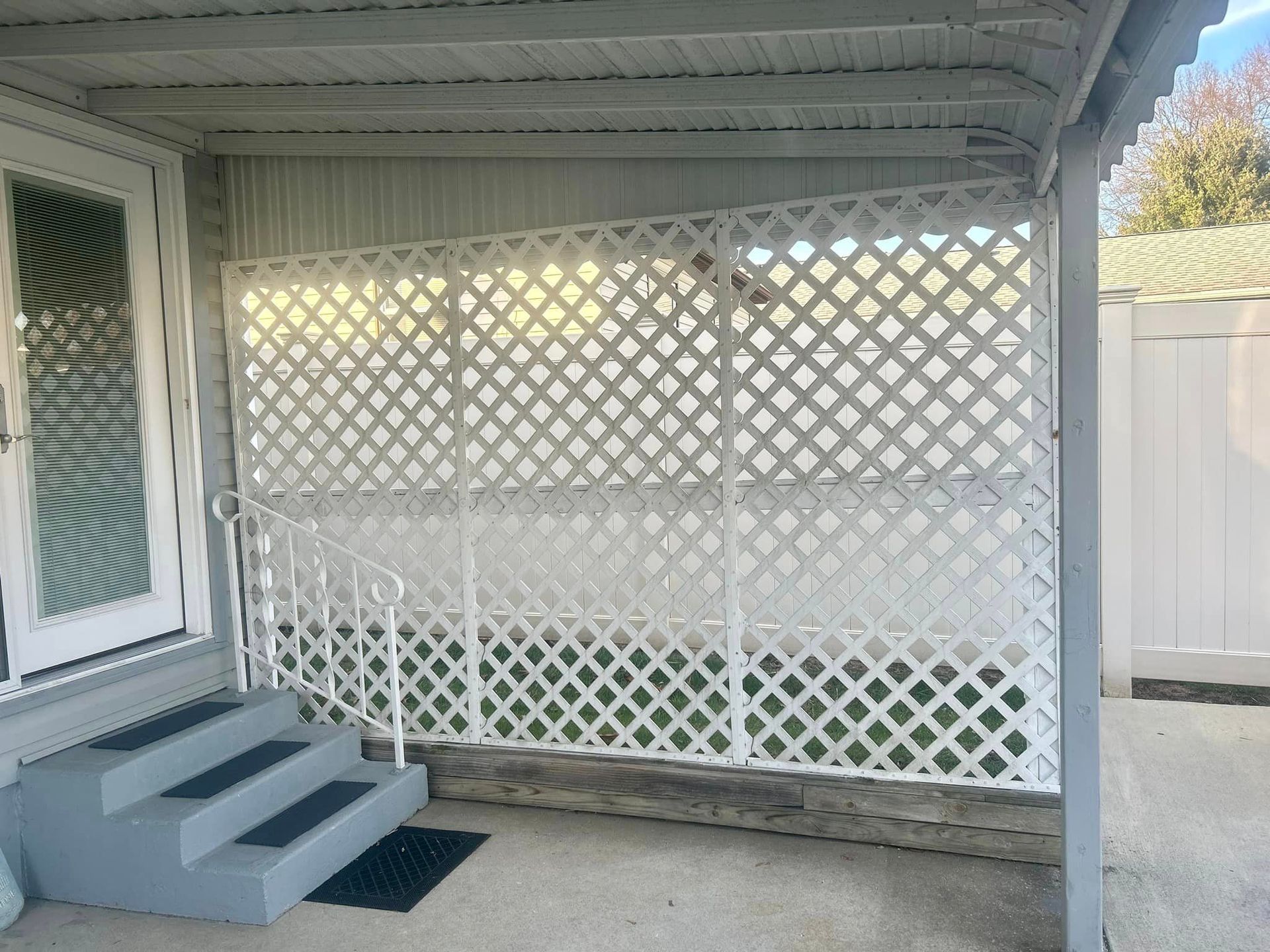 A porch with stairs and a white lattice wall