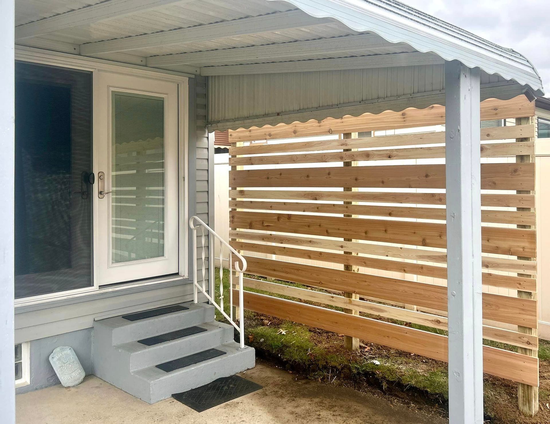 A porch with a wooden fence and stairs leading to it.