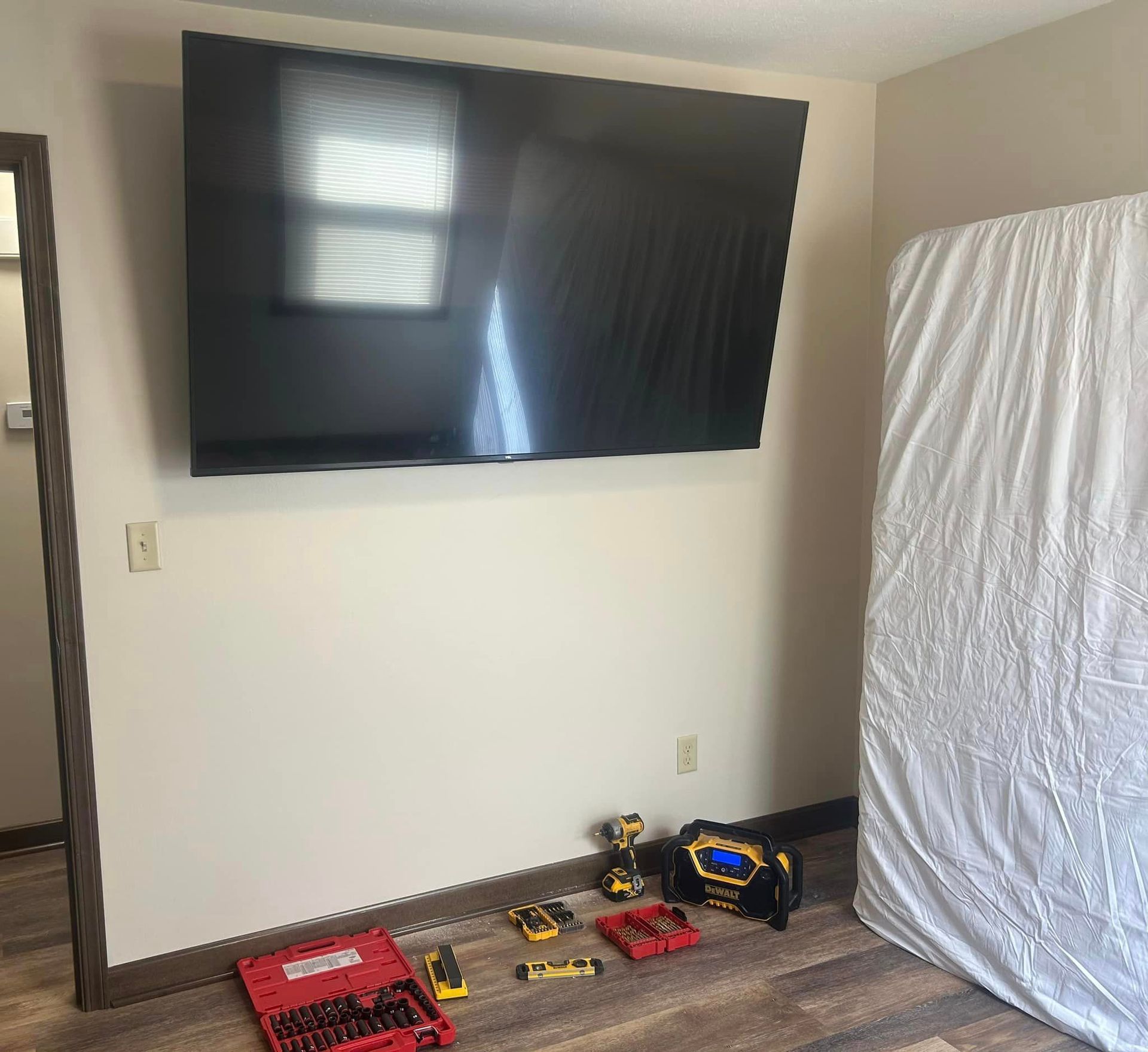 A large flat screen tv is mounted on a wall in a room.
