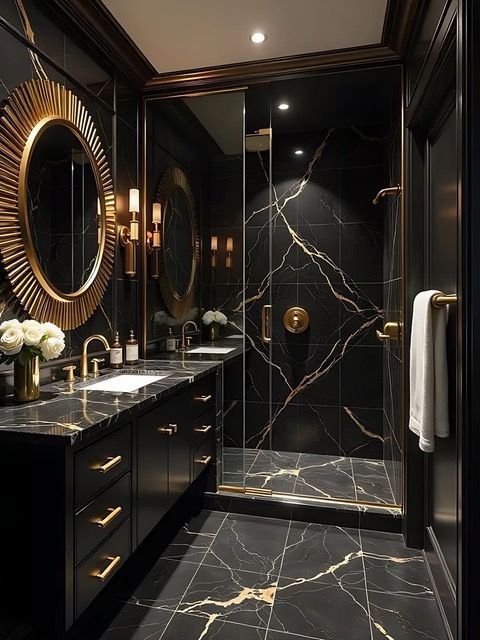 Luxurious black marble bathroom with gold accents. Includes vanity, shower, and oval mirrors.