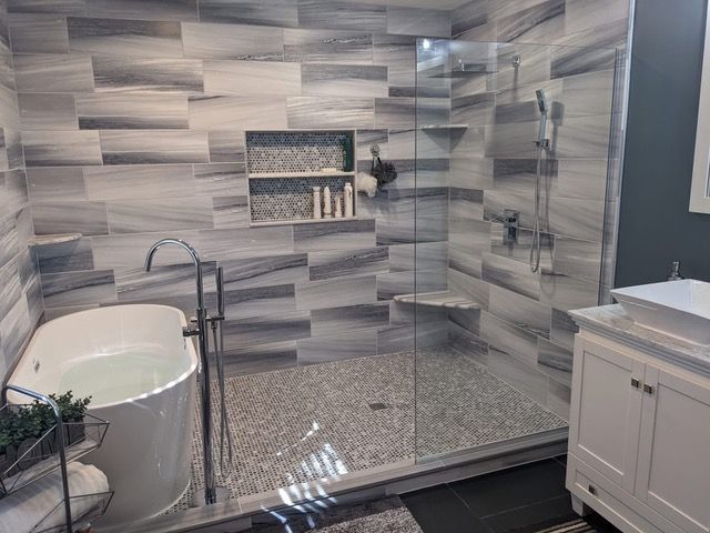 Modern bathroom with tiled walls, walk-in shower, and freestanding tub.