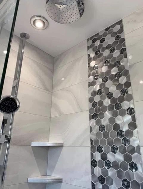 Modern shower with gray and white tile, a rain showerhead, and a shelf.