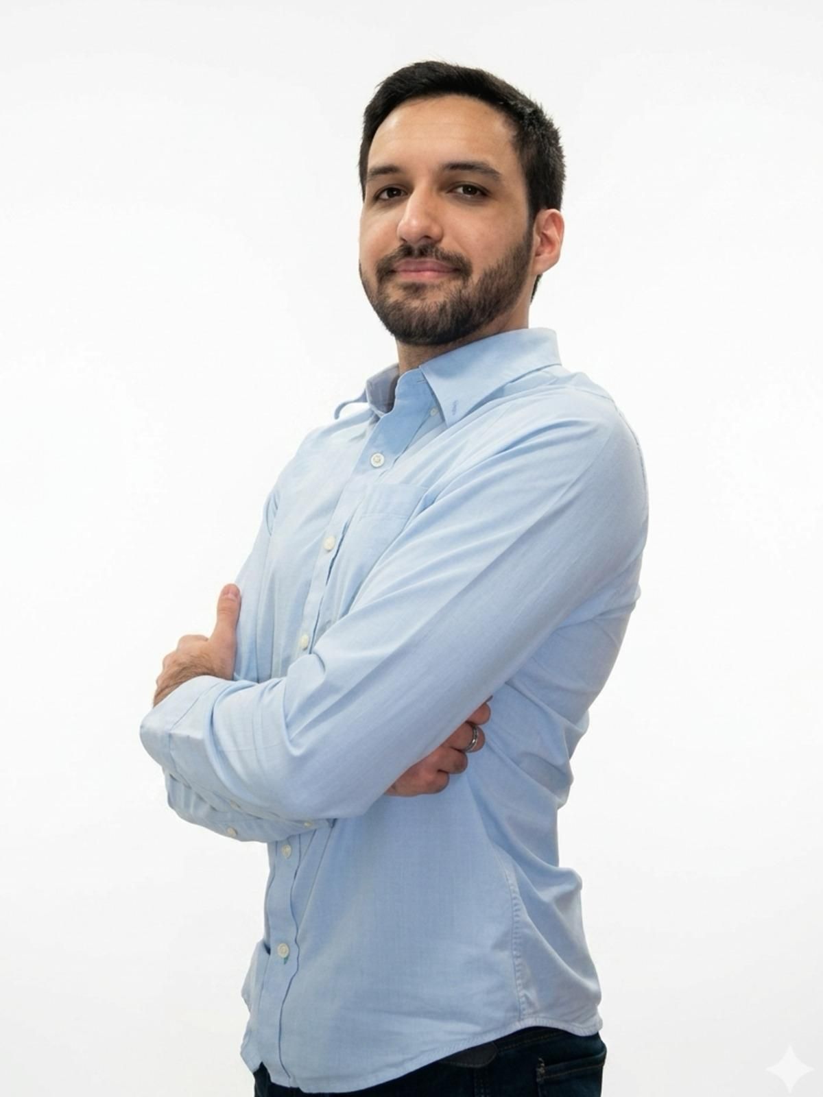 Retrato de un hombre con una camiseta azul claro sobre un fondo gris liso.