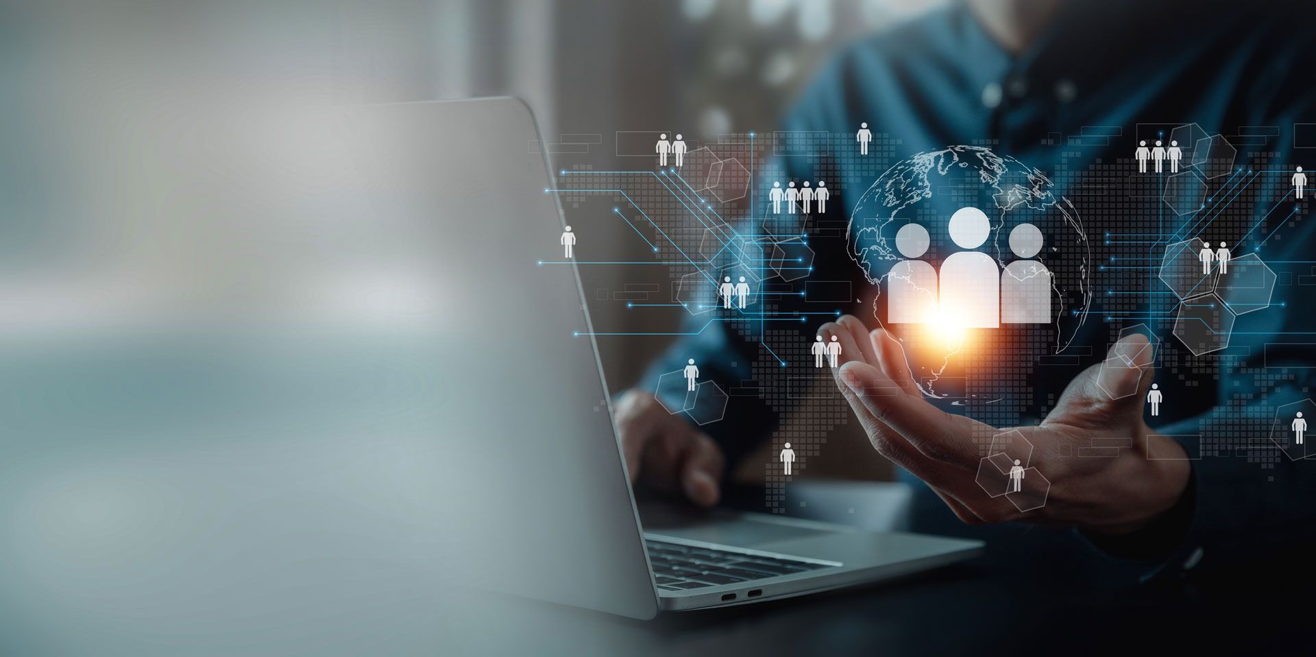 Person holding a glowing human silhouette over a laptop, representing global networking.