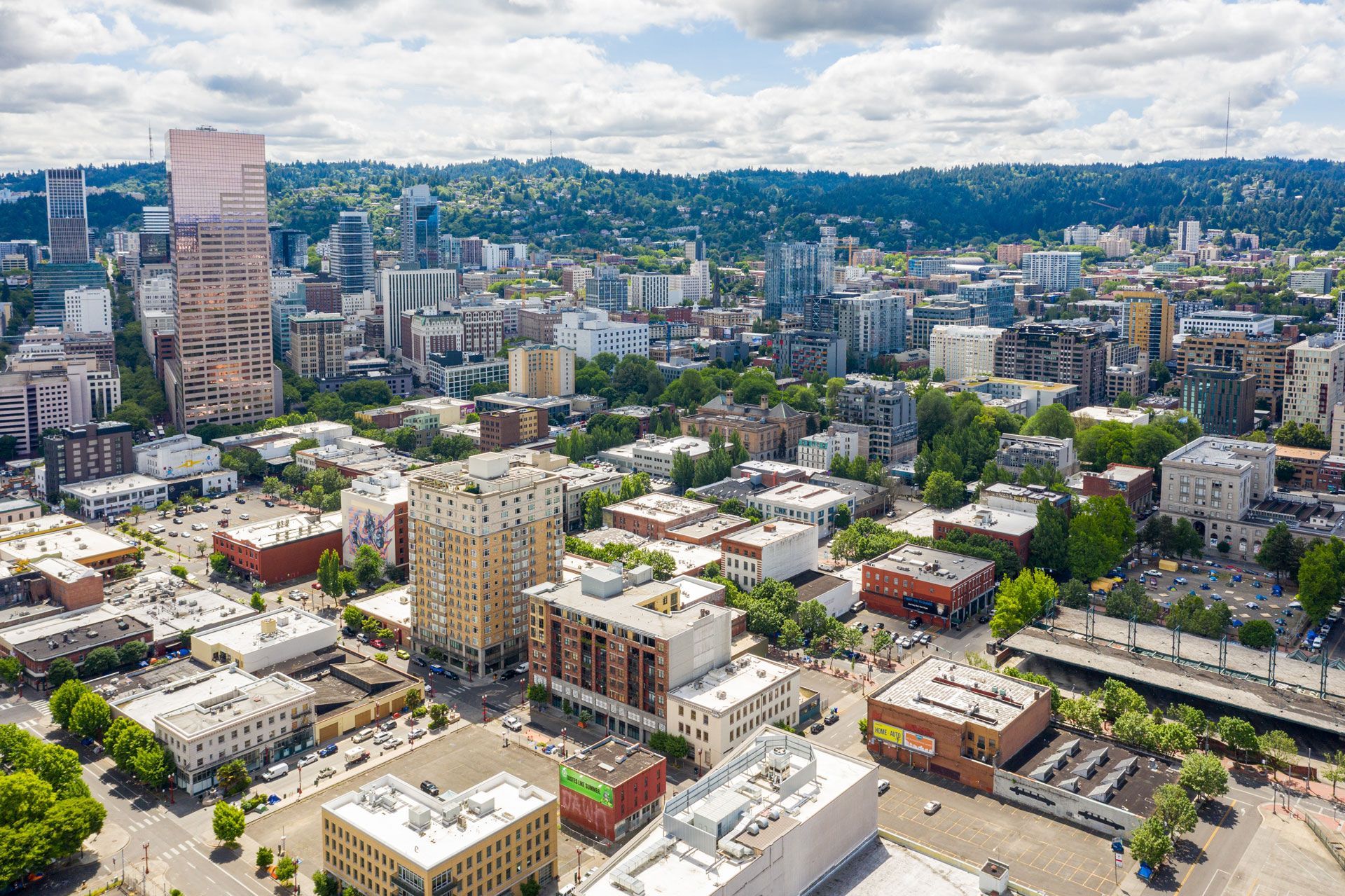 Aerial view of Portland, Oregon; buildings and trees under a cloudy sky.
