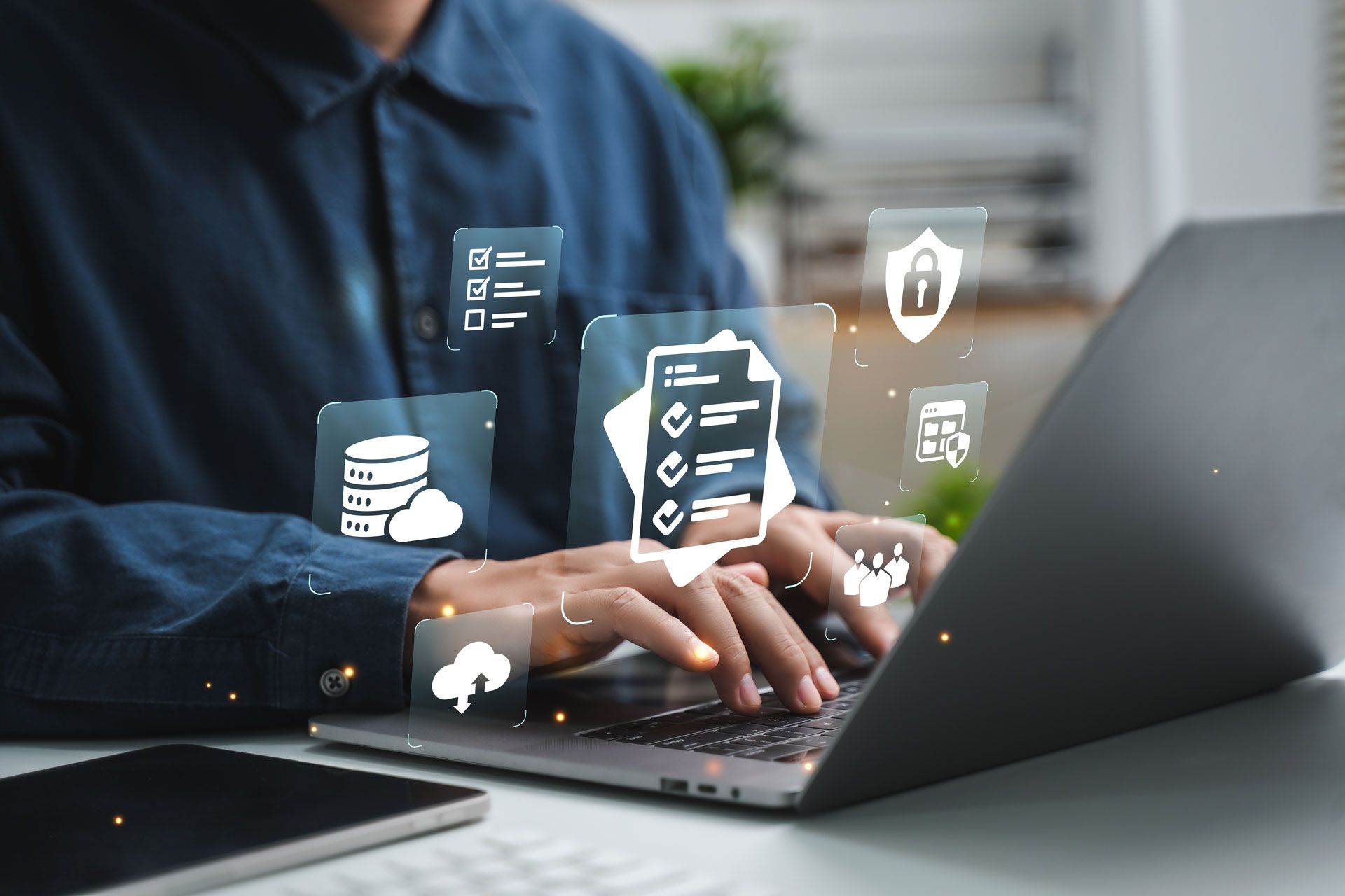 Person typing on laptop with digital icons overlaid.