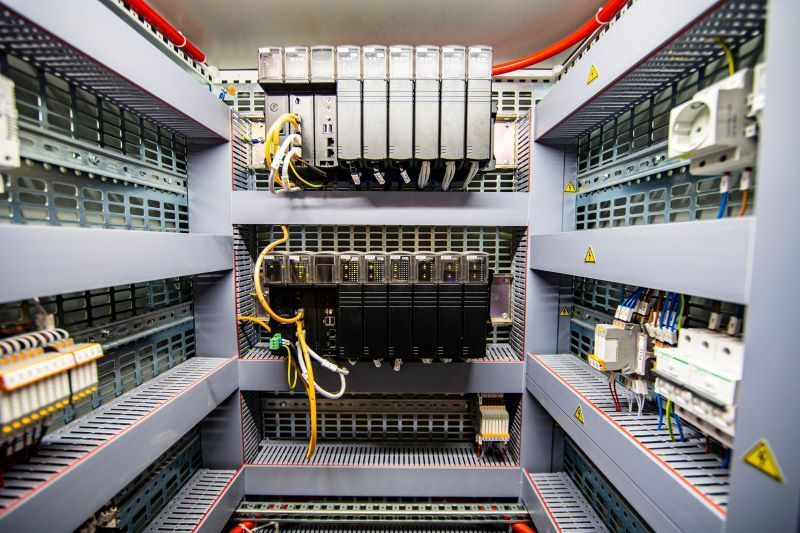 A person is holding two gauges in their hands in front of a building.