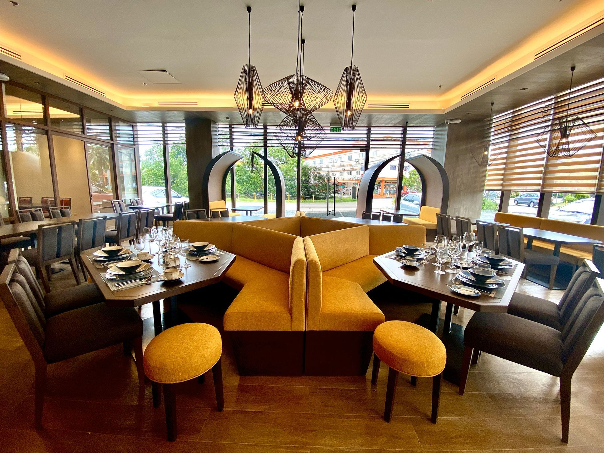 Restaurant dining area with a yellow booth, tables, and ornate light fixtures.