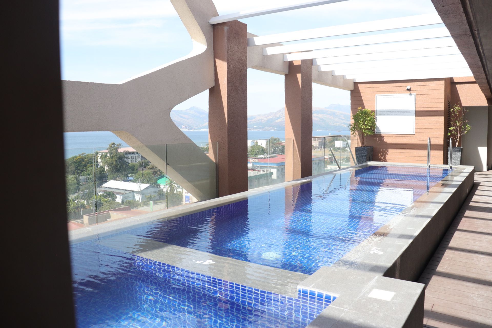 A large swimming pool with a view of the ocean at Aurora Subic Hotel