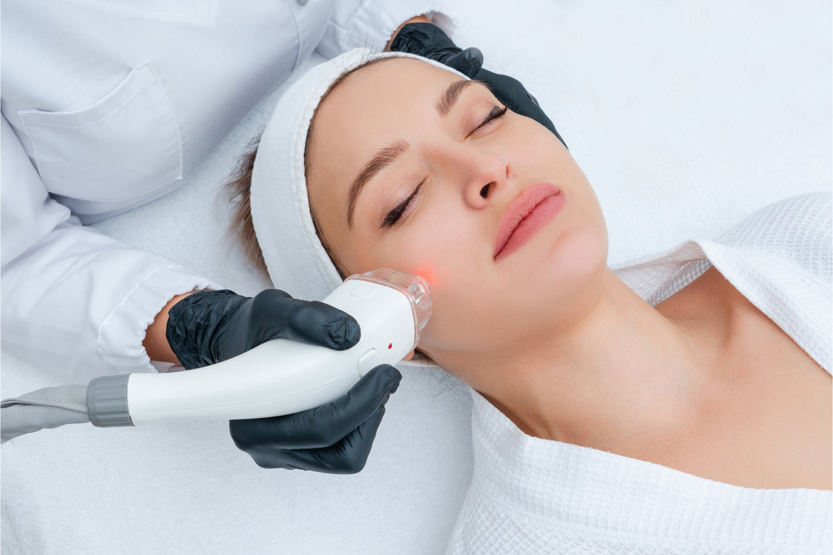 Woman receiving facial laser treatment at a spa.