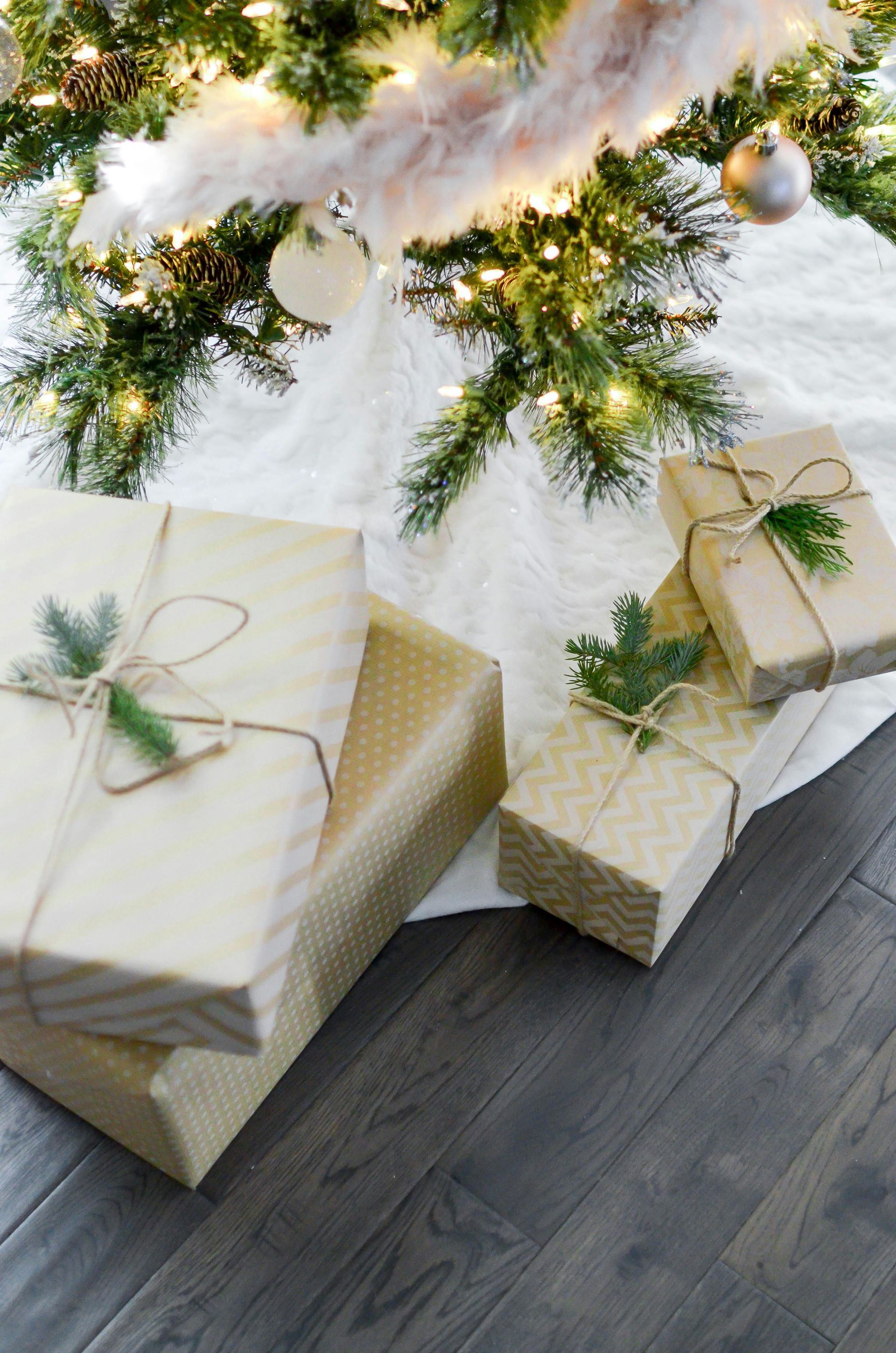 Christmas gifts wrapped in brown paper under a decorated tree.