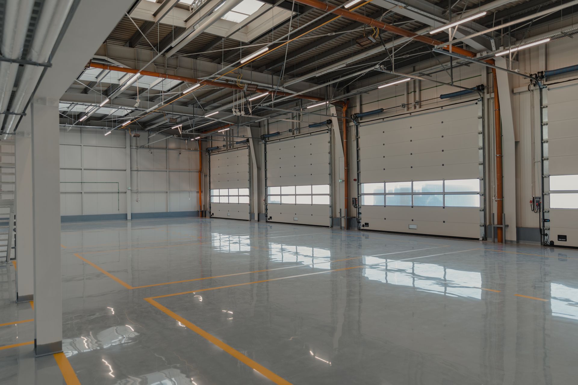 A large empty warehouse with lots of doors and windows.