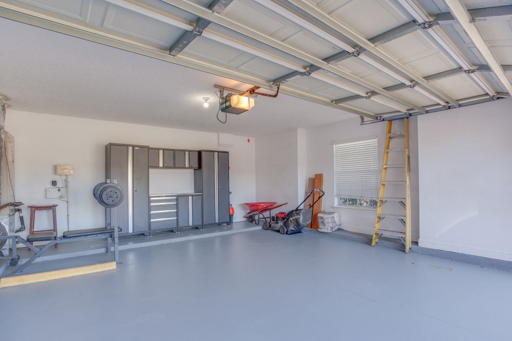 A garage with a ladder and a lawn mower in it.