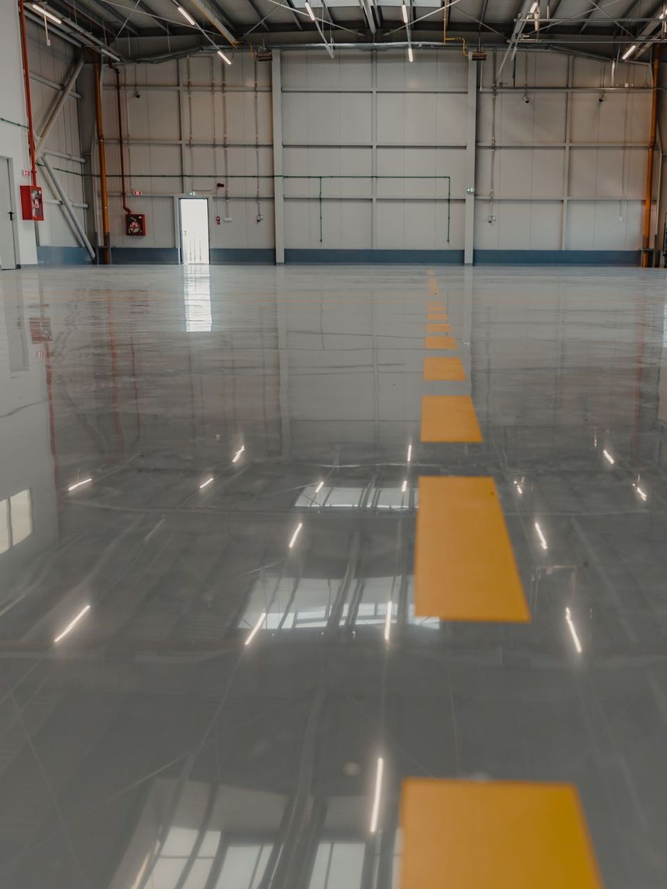 A large empty warehouse with a yellow line on the floor.