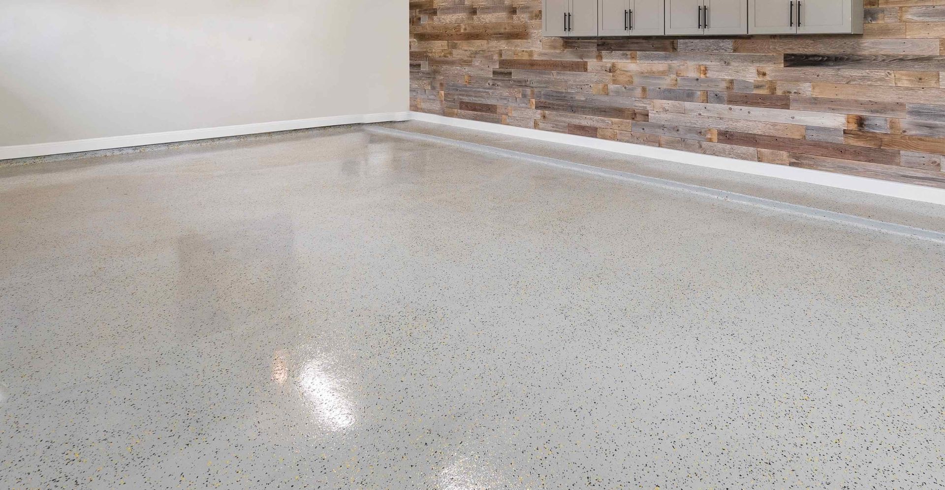 A garage with a concrete floor and a stone wall.