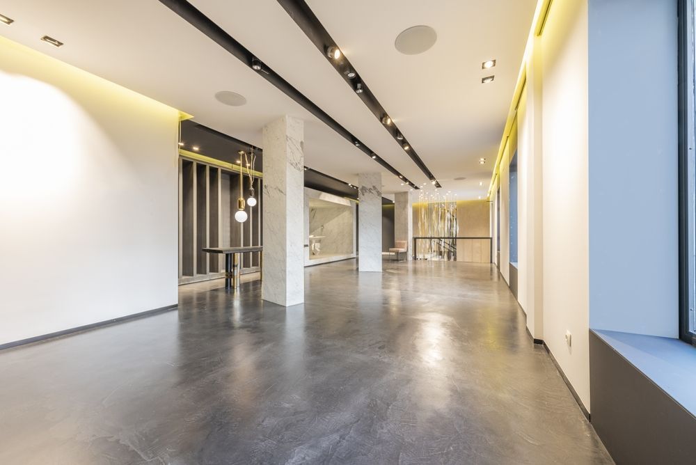 A large empty room with a black floor and white walls.