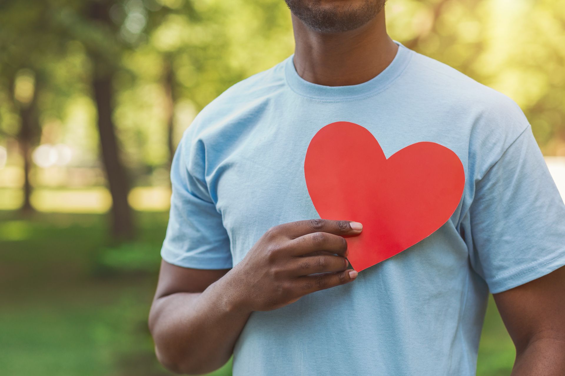 anonymous man holding a heart over his chest, heart health concept