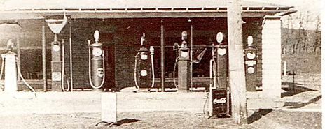 An old gas station with multiple fuel pumps under a covered area.