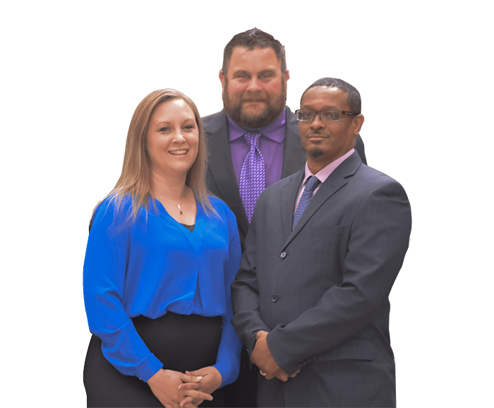 A woman in a blue shirt is standing next to two men in suits.