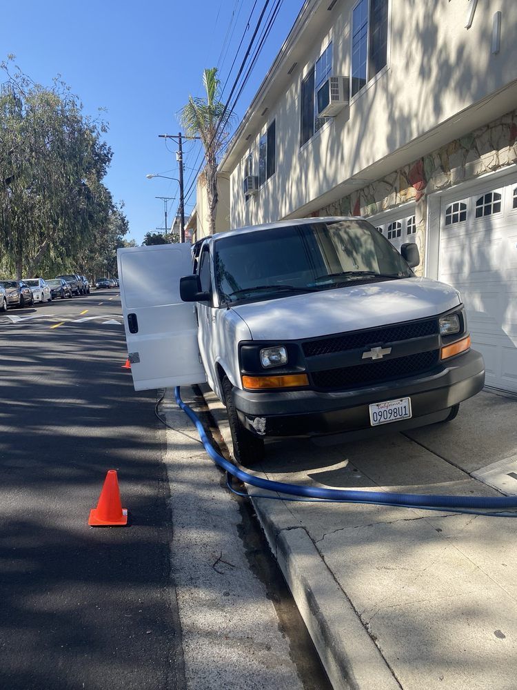 A white van is parked on the side of the road with its door open.