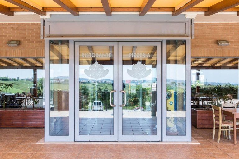 Ingresso in alluminio di un hotel con portone e vetrate realizzati da Cesari srl di Recanati