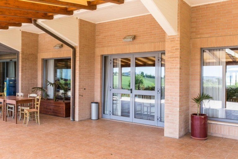 Portone a due ante di un ingresso di un ristorante in alluminio realizzato da Cesari srl di Recanati