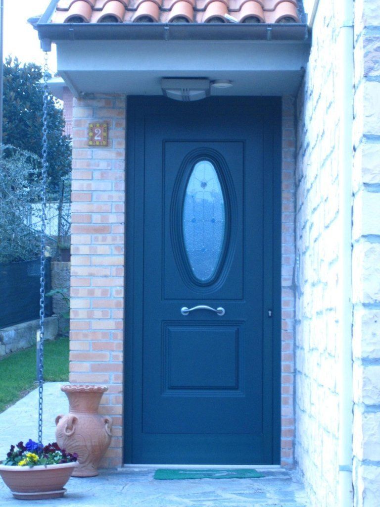 Portone di ingresso in alluminio con pannello decorativo e finestra ovale realizzato da Cesari srl di Recanati