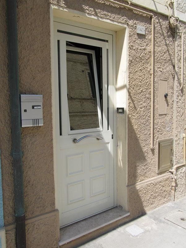 Portone di ingresso in alluminio con parte superiore a ribalta realizzato da Cesari srl di Recanati
