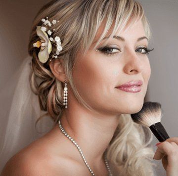 woman with styled hair holding a makeup brush