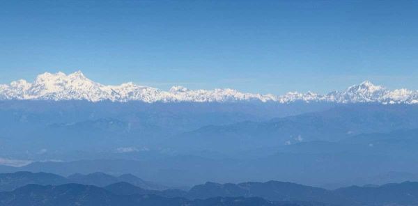 Snow-capped Himalayan mountain range under a clear blue sky.