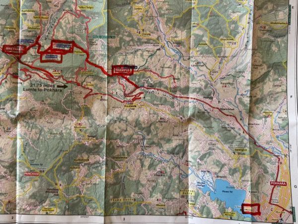 Folded map with a highlighted red route through a mountainous area, including labeled locations.