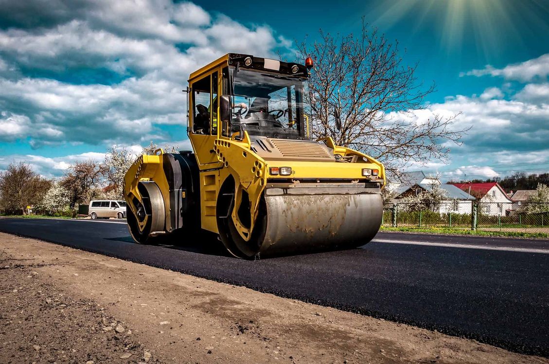 A group of construction workers are working on a road under construction.