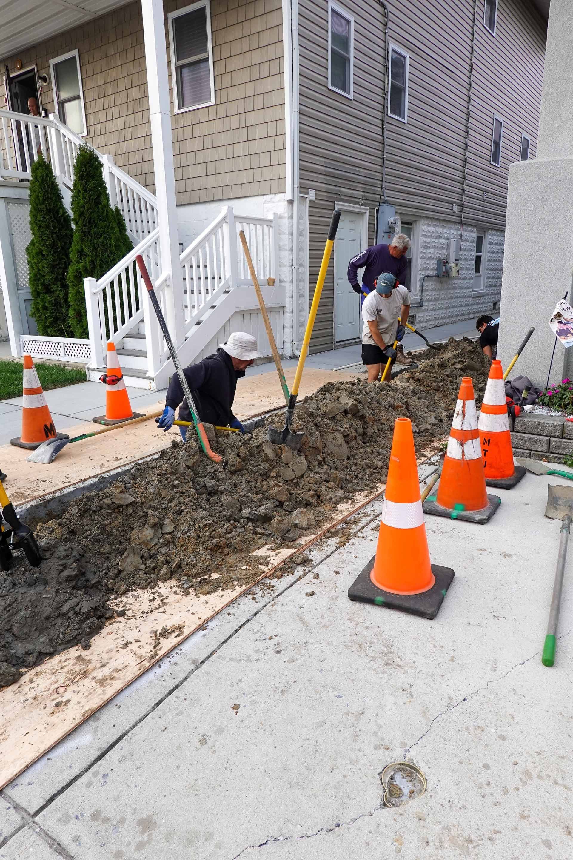 A group of construction workers are digging a hole in the ground.