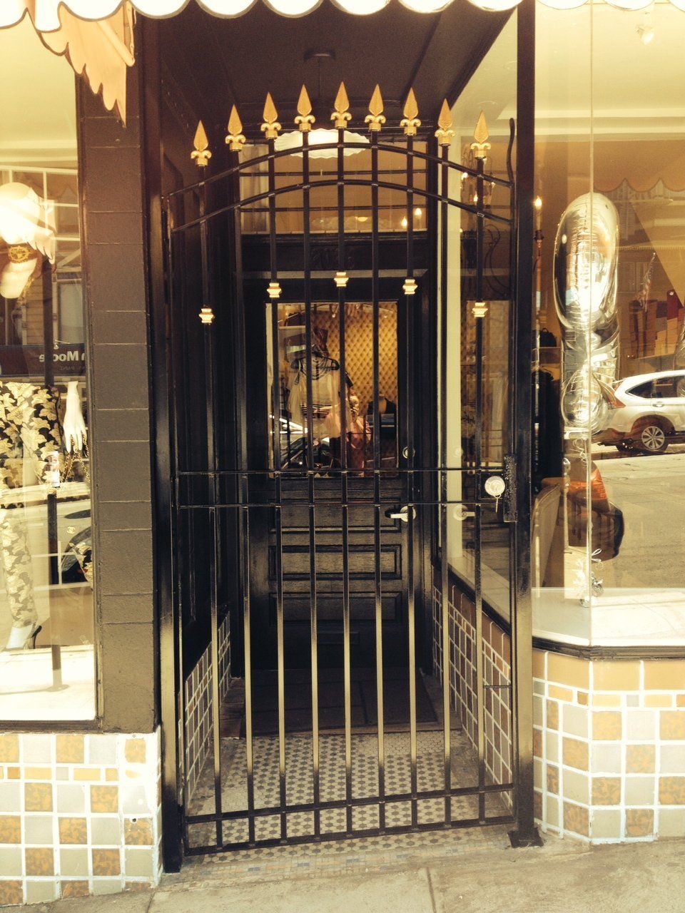 A store front with a wrought iron gate leading into it