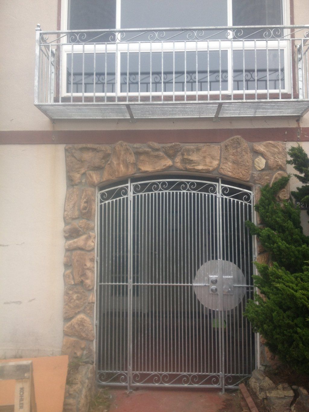 A building with a balcony and a gate in front of it.