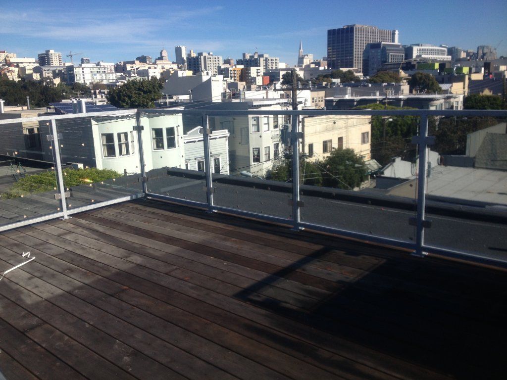 A view of a city from a balcony with a glass railing