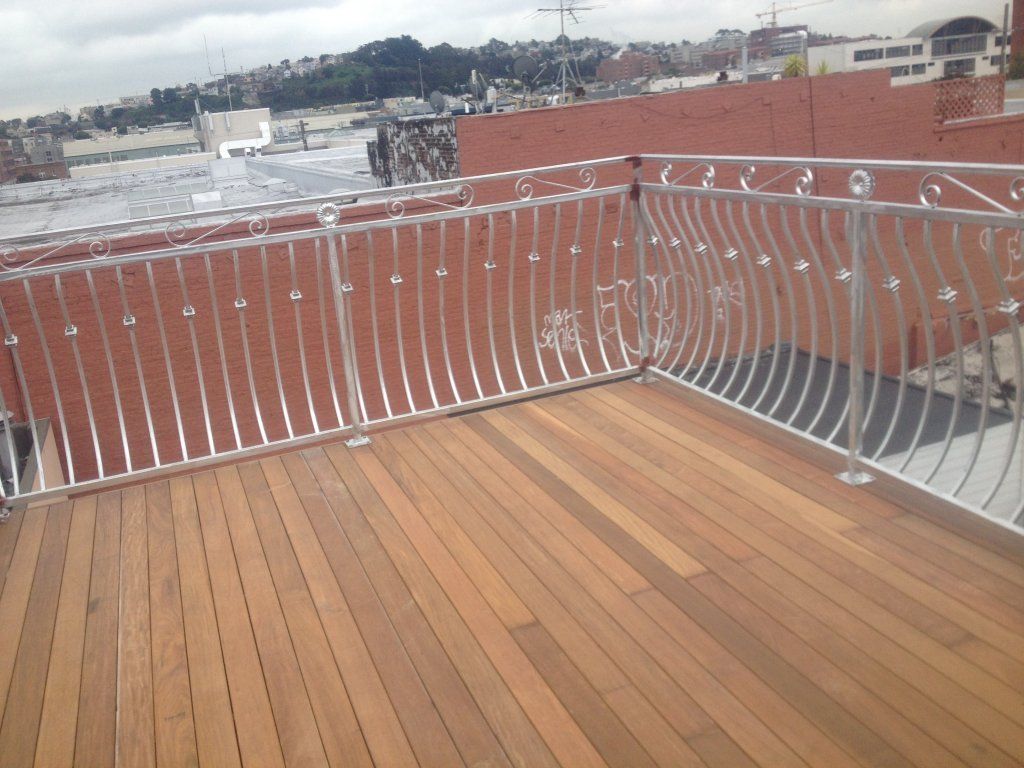 A balcony with a wooden deck and a metal railing