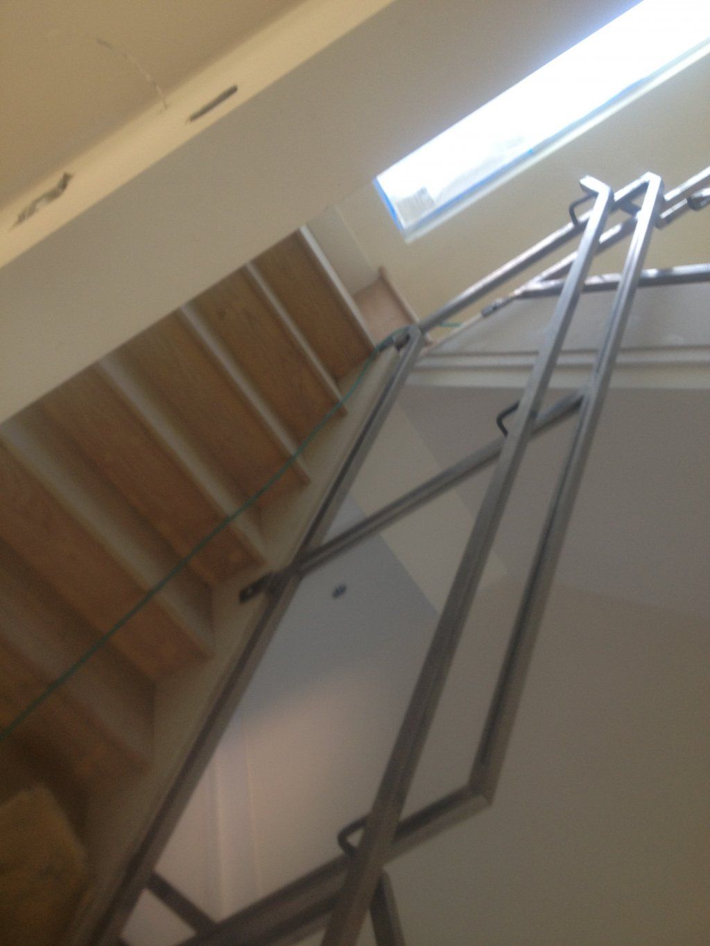 A staircase with a metal railing and a window