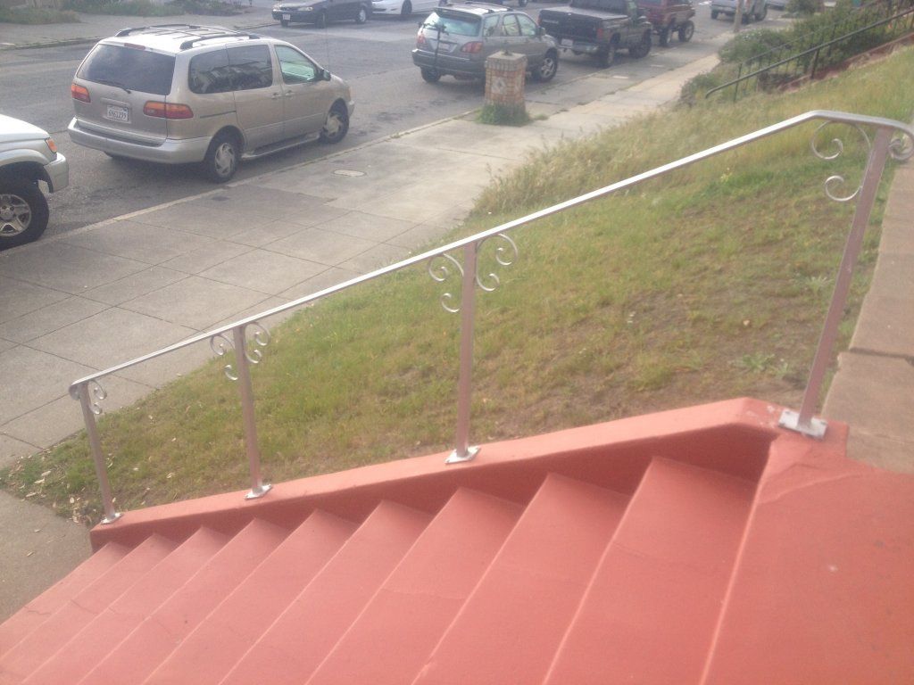 A van is parked on the side of the road next to a set of stairs.