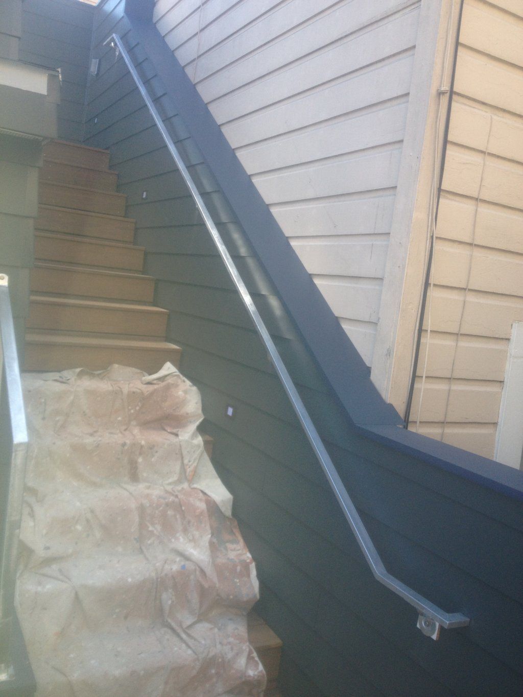A set of stairs leading up to a building with a blue railing