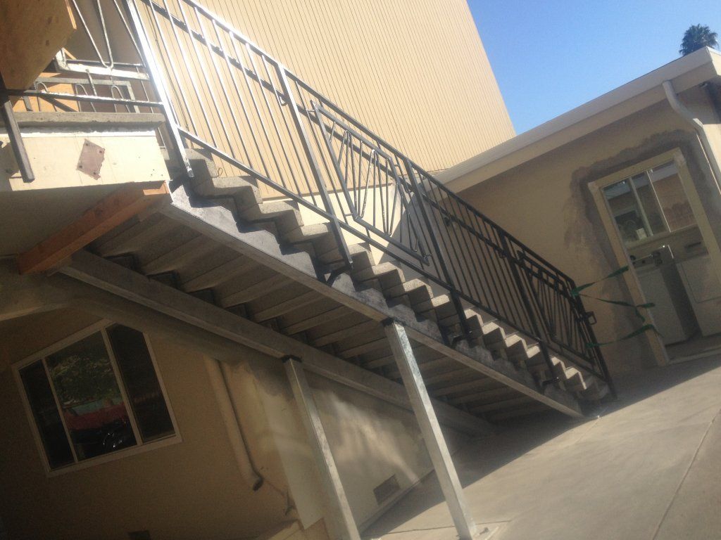 A set of stairs leading up to a house with a wrought iron railing