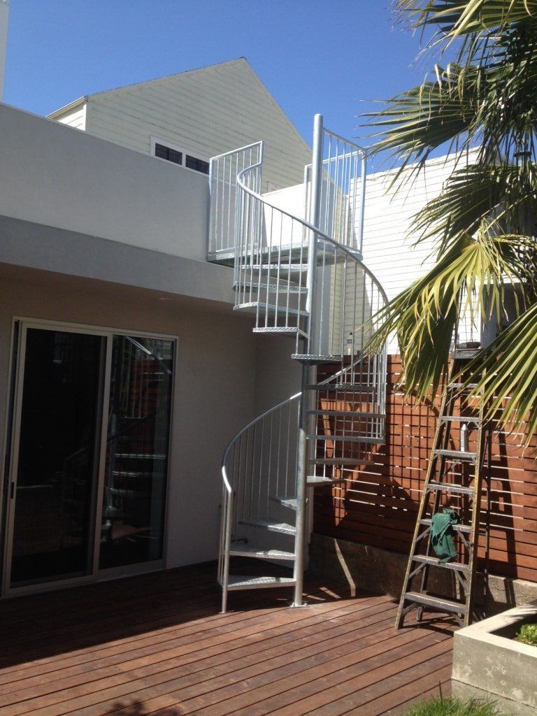 A spiral staircase is leading up to the second floor of a house.