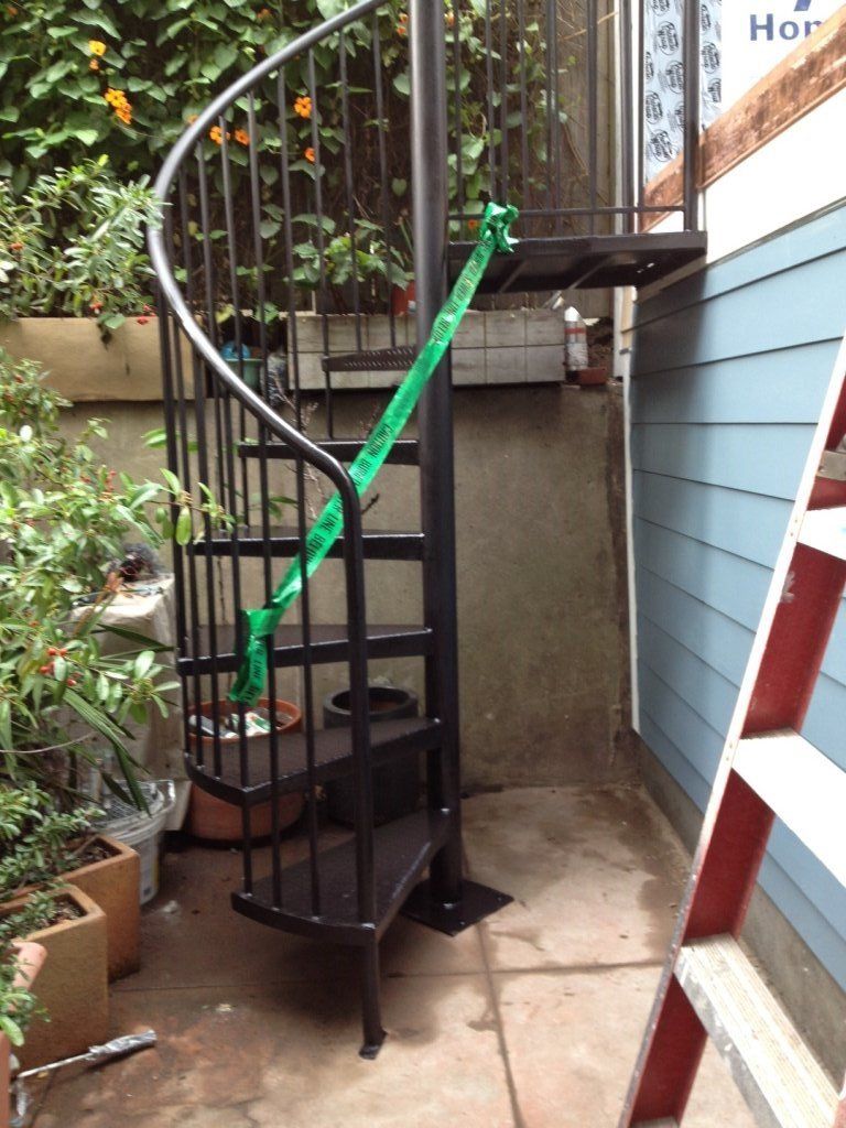 A spiral staircase with a green ribbon attached to it