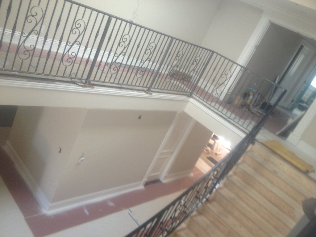 An aerial view of a staircase with a wrought iron railing.