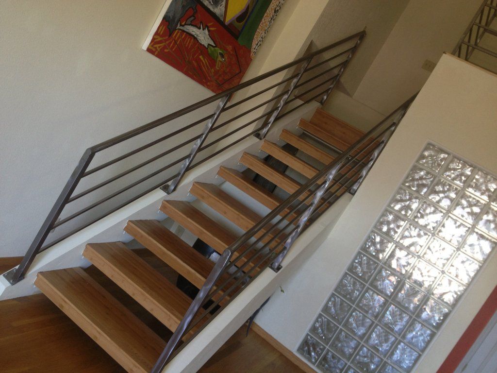A staircase with a metal railing and wooden steps