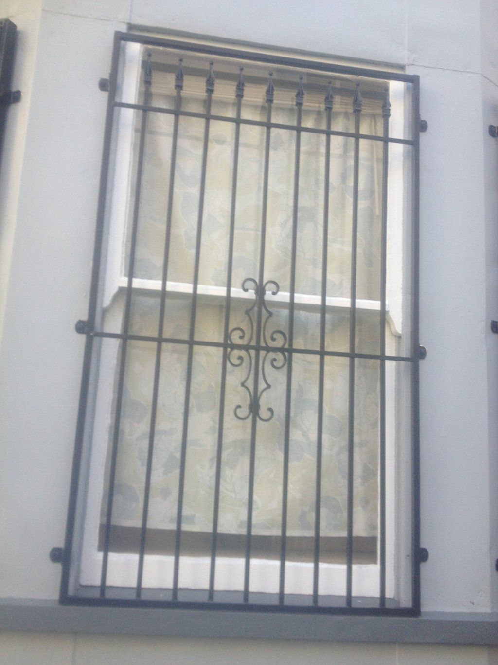 A window with a wrought iron grille on it