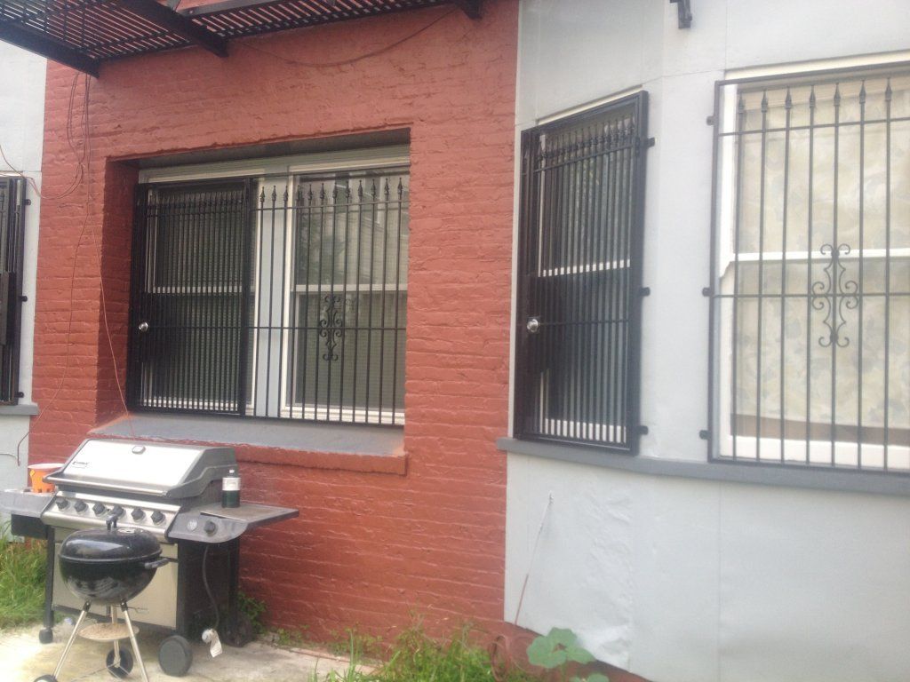 A grill is sitting outside of a brick building
