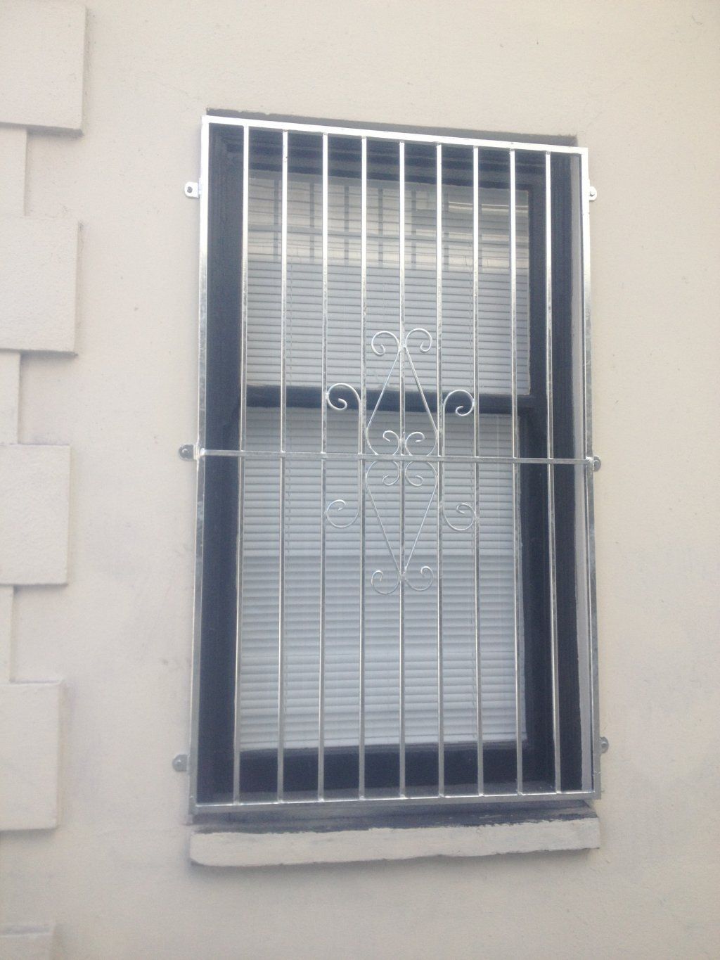 A window with a stainless steel grill on it