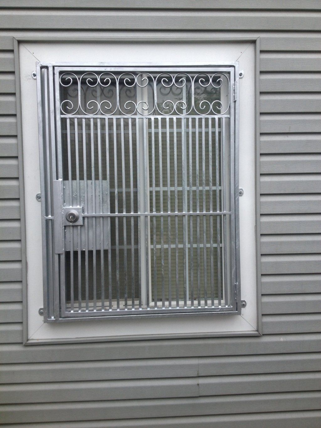 A window with a metal grill on the side of a building.