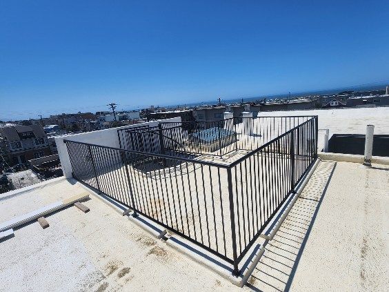 There is a fence on the roof of a building.